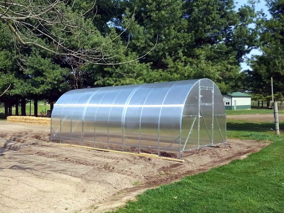 A walk-in polycarbonate greenhouse kit on a hot-dip galvanized steel frame, installed on a prepared base
