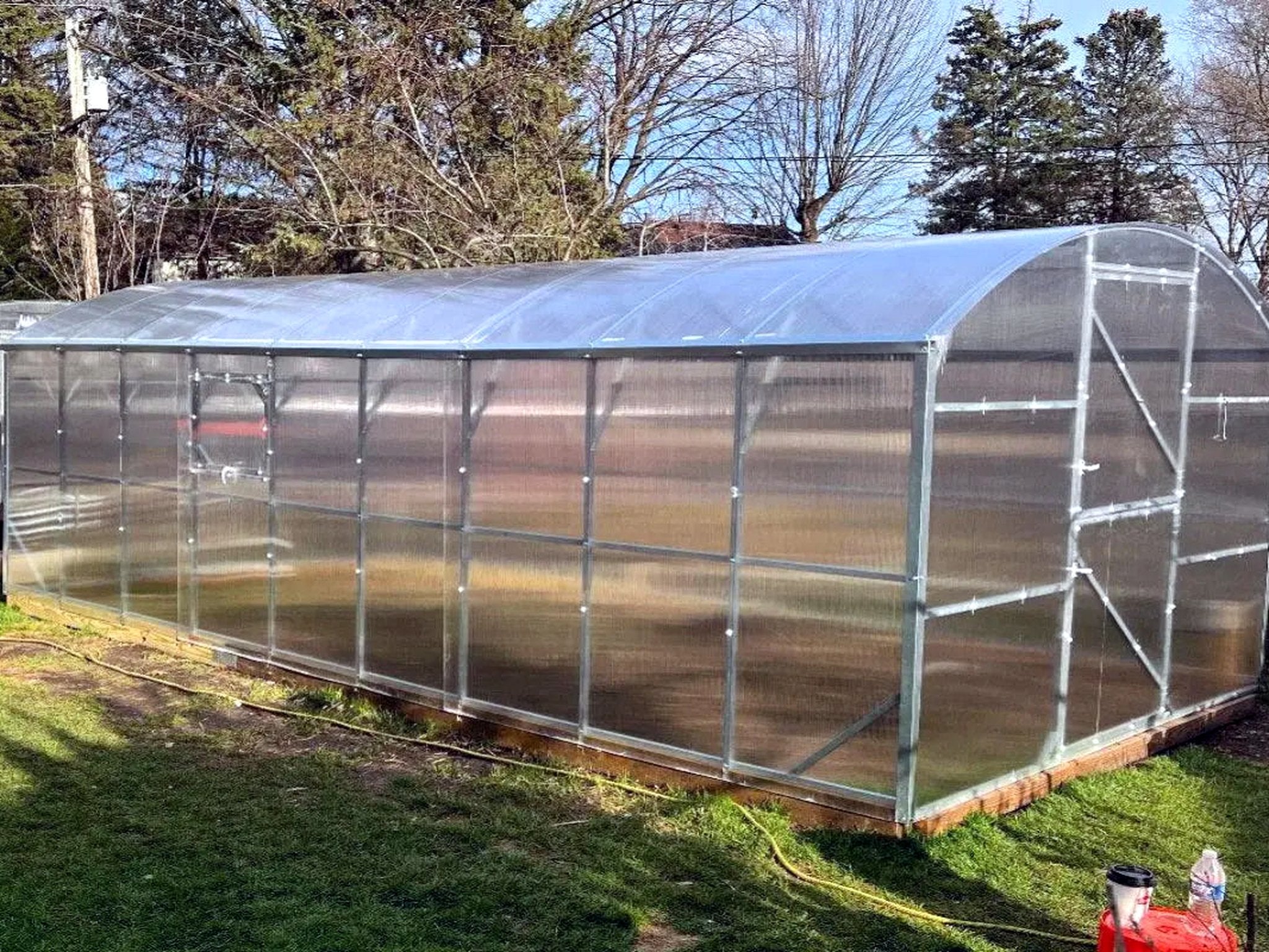 Loft Series greenhouse with straight galvanized steel side walls under an arched twinwall polycarbonate roof